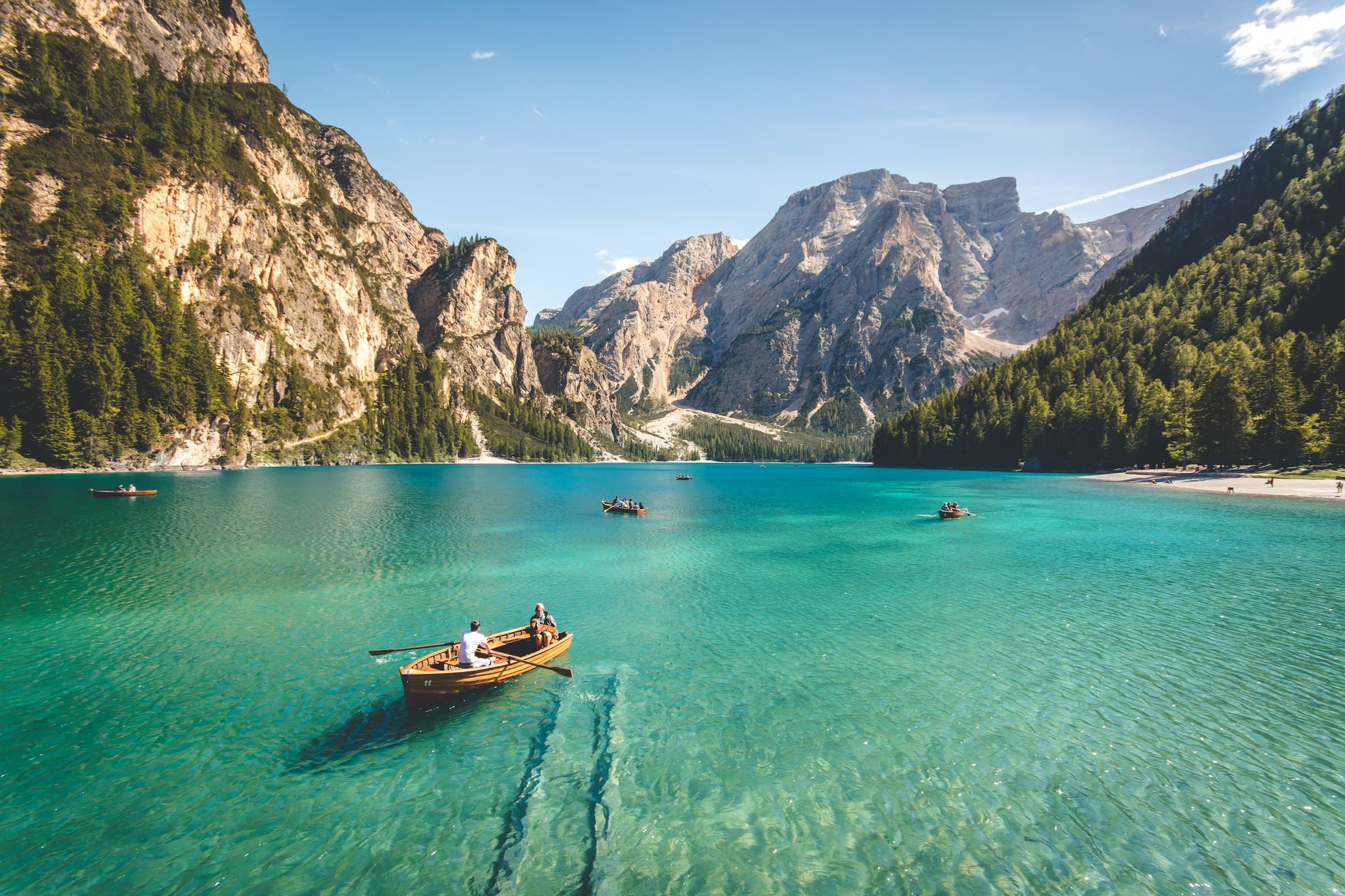 A still alpine lake under sunlit mountains — travel as a long view.